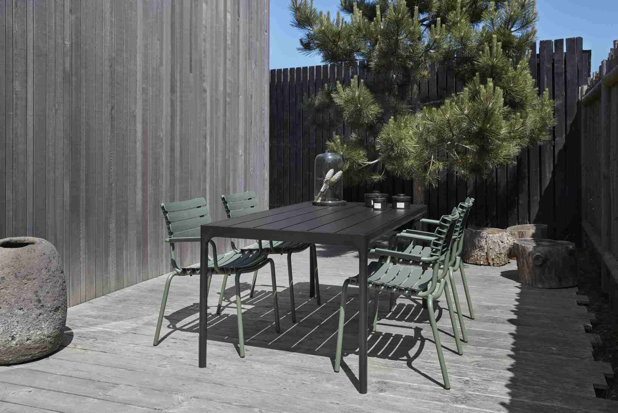 Houe Four Esstisch Outdoor mit Stühlen auf Holzterrasse, modernes Gartendesign.