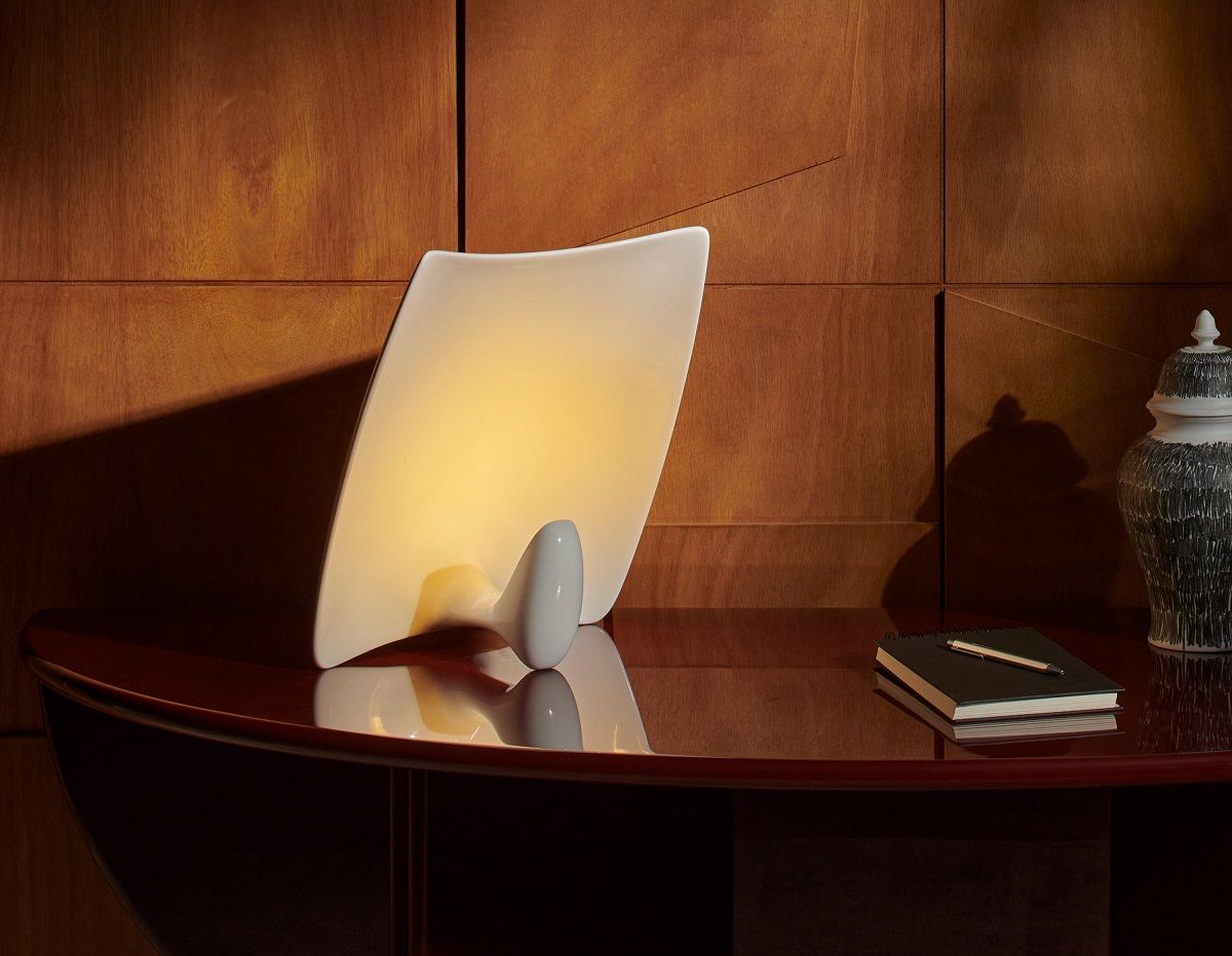 Valor.S Tischleuchte Keramik Cassina Gold auf einem Tisch, daneben ein Notizbuch und eine dekorative Vase.