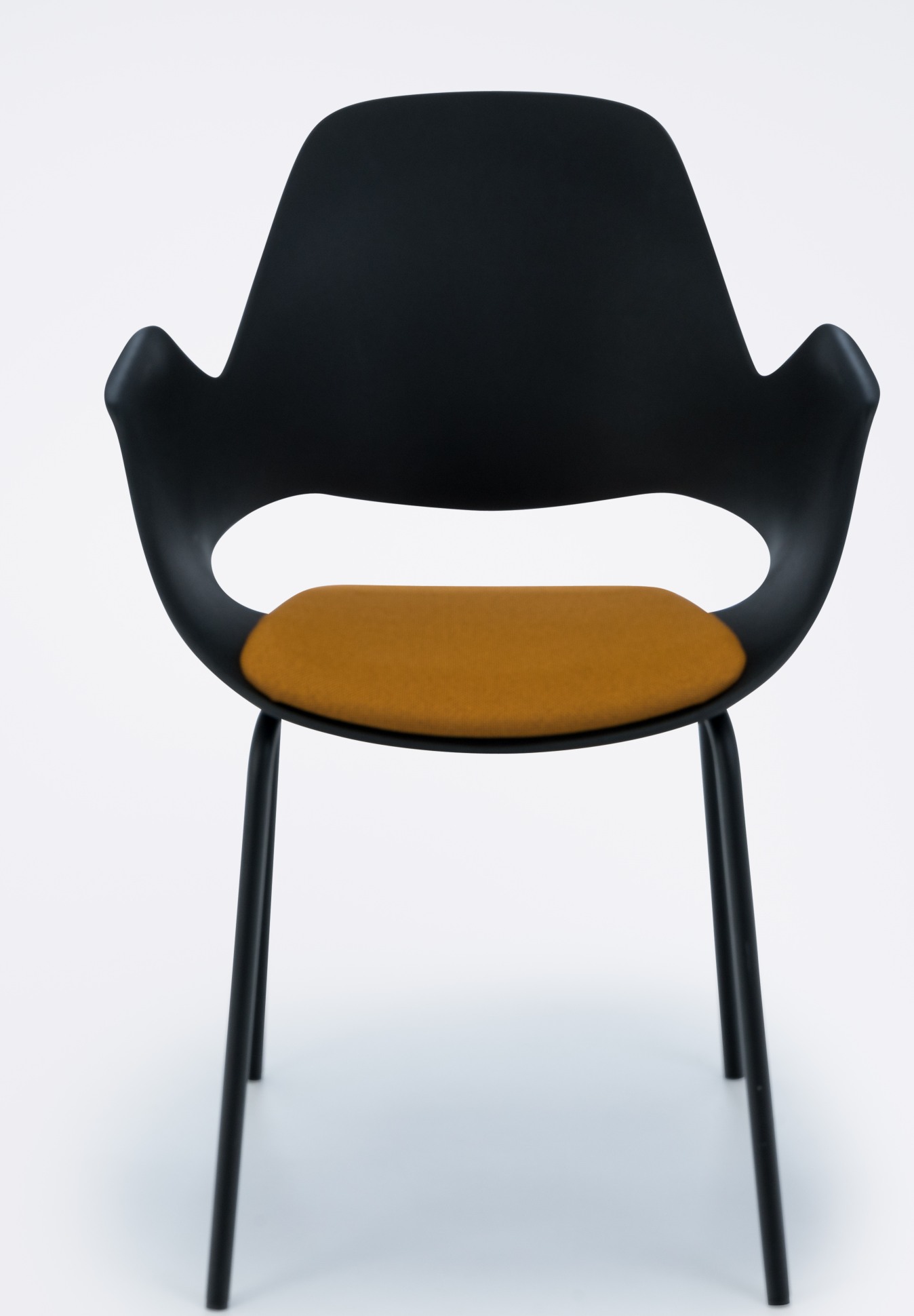 Falk Stuhl von Houe: Schwarzer Design Stuhl mit Armlehne und gelber Sitzfläche. Metallbeine.