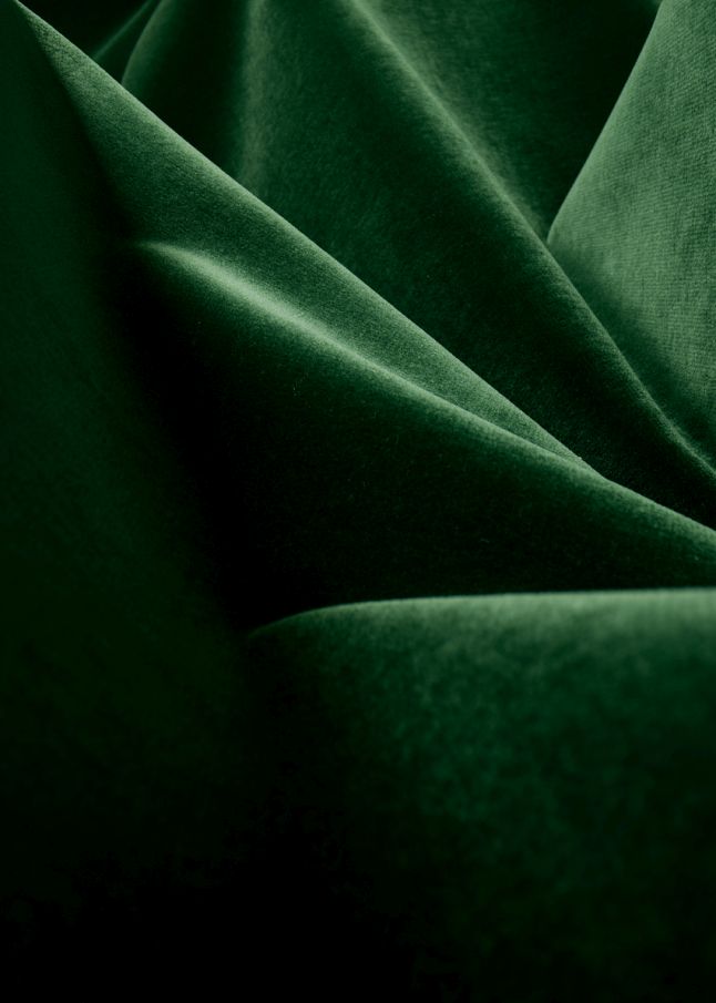 Detailaufnahme: Grüner Samtbezug des Beetle Chair Stuhls von Gubi, luxuriöses Möbeldesign.