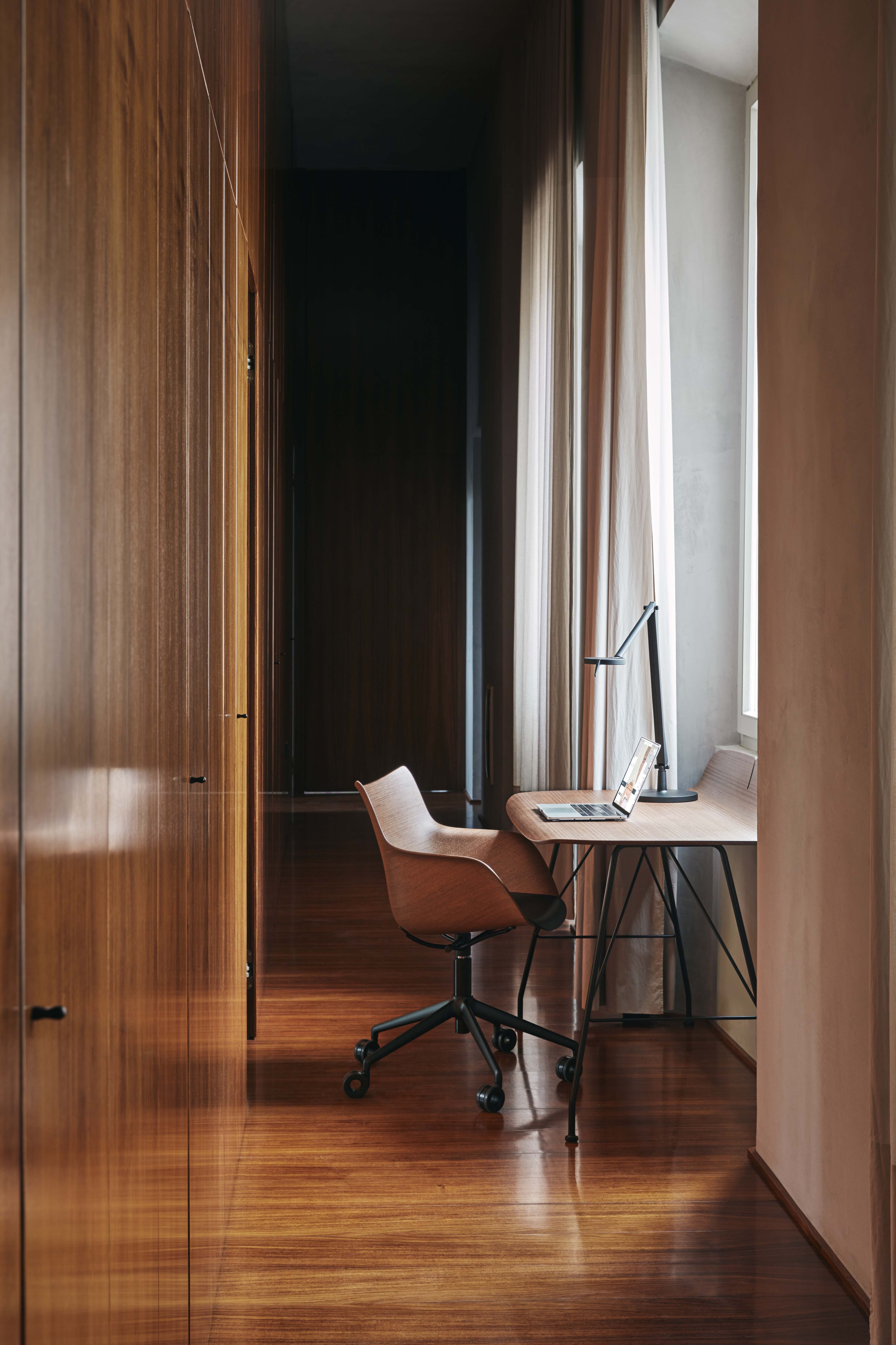 Q/Wood Drehstuhl mit dunklem Holz und verchromtem Gestell in einem modernen Büro.