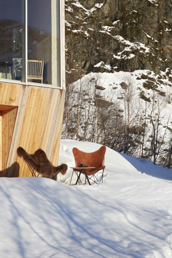 Iceland Mariposa Butterfly Chair Sessel Schaffell und Cuero Leder im Schnee vor einem Haus.