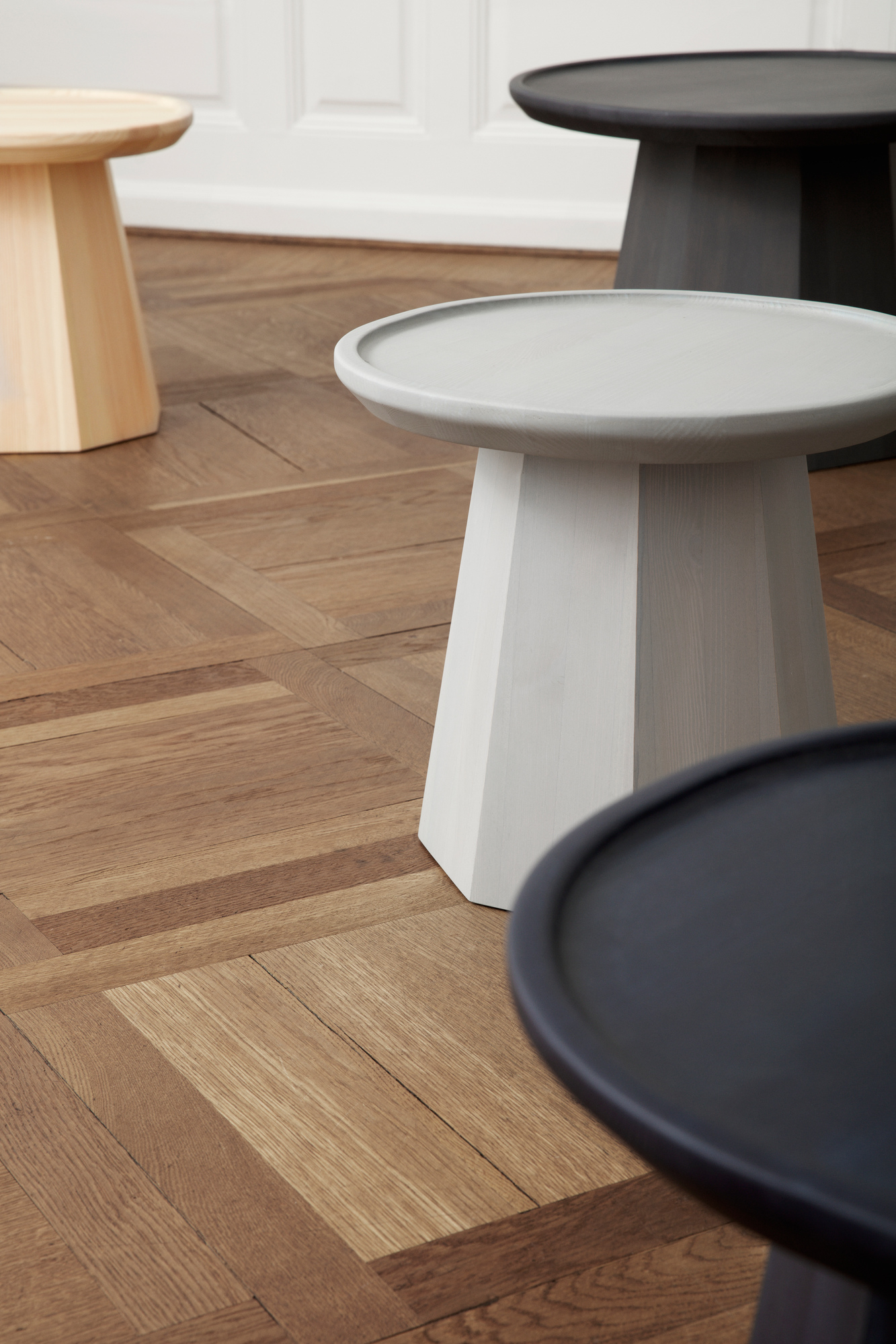 Nahaufnahme von mehreren Normann Copenhagen Pine Table Beistelltischen in verschiedenen Farben.