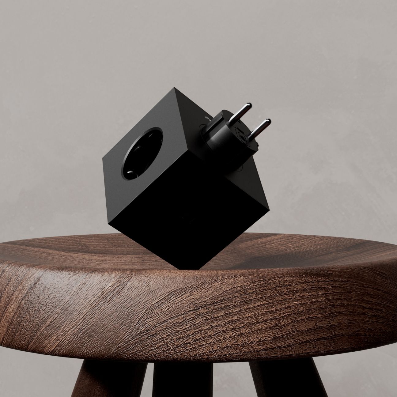 Schwarzer Avolt Square 2 Steckdosenwürfel mit USB-C Anschluss auf einem Holzschemel.