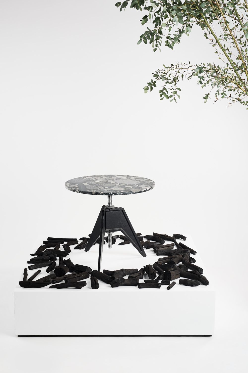 Screw Café Table von Tom Dixon mit runder Tischplatte und schwarzem Metallfuß.