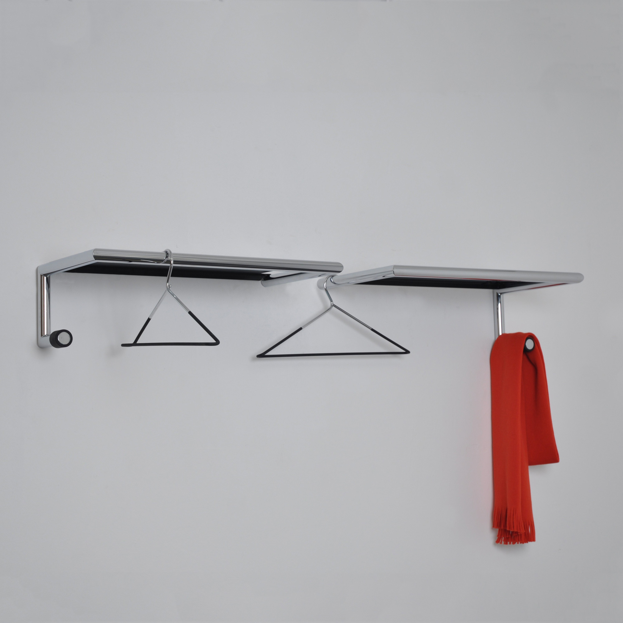 Link 55 Wandgarderobe mit Hutablage Mox: Chromfarbene Garderobe mit Haken und rotem Schal.