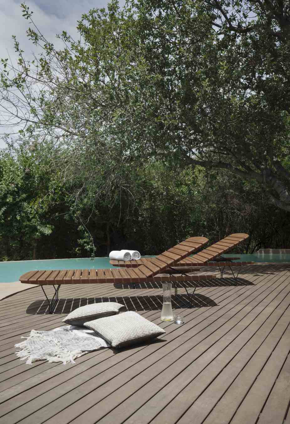 Molo Outdoor Kissen für Houe Sonnenliege auf Holzdeck am Pool, entspannte Gartengestaltung.
