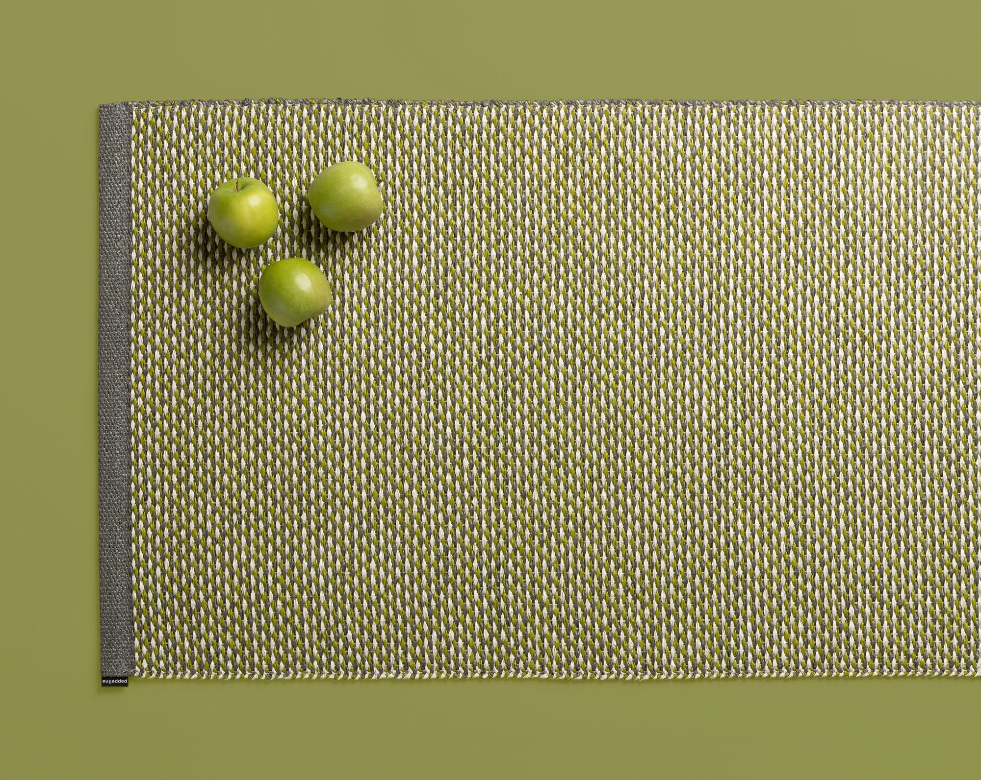 Effi Kunststoffteppich von Pappelina, 70x200 cm, in Grün-Weiß mit drei grünen Äpfeln.