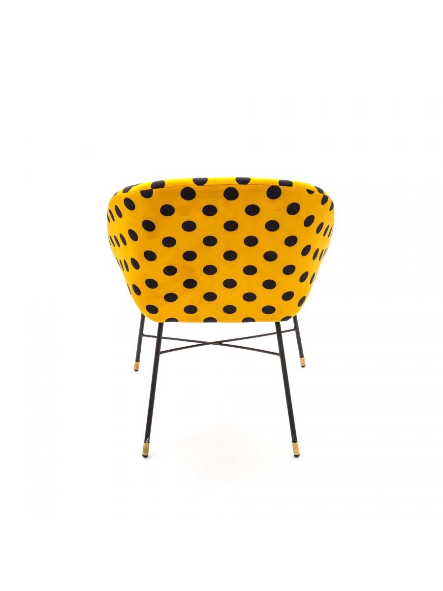 Toiletpaper Polsterstuhl Shit Seletti von hinten: Gelber Sessel mit schwarzen Punkten und Metallbeinen.