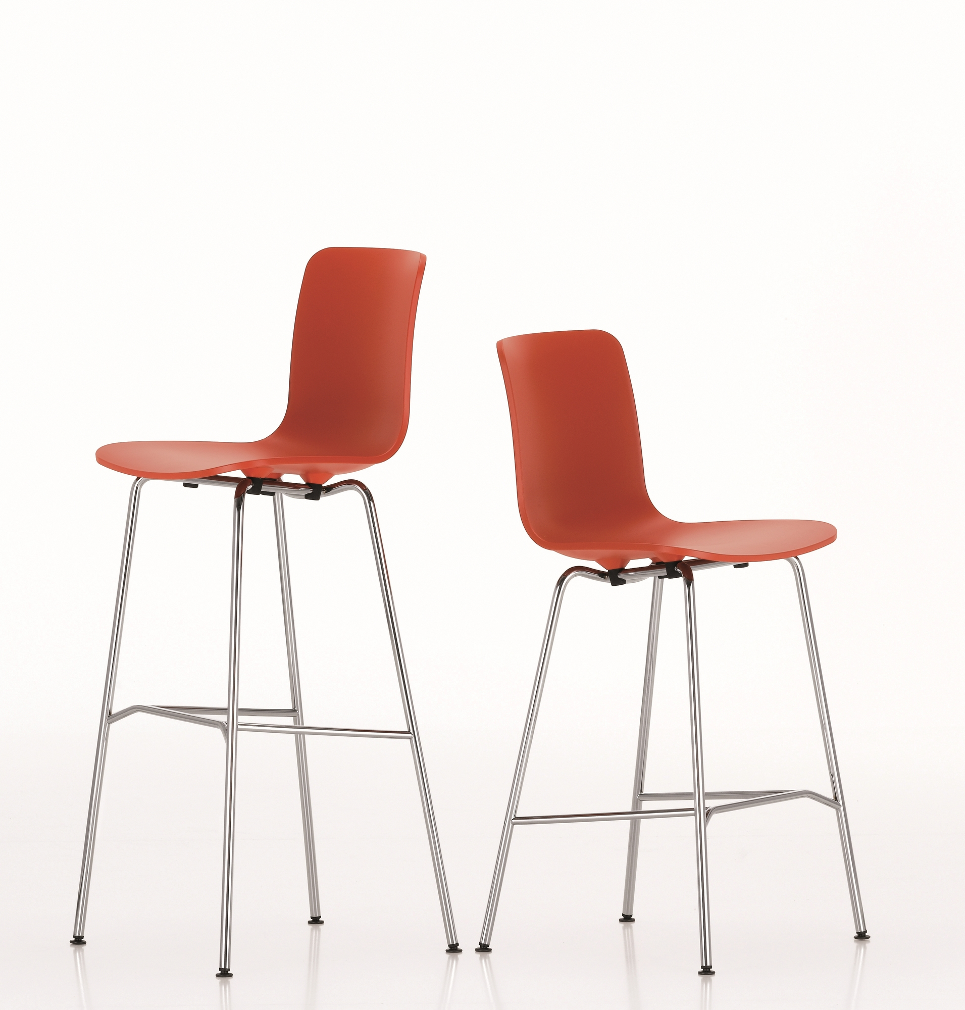 Zwei rote Hal Barhocker von Vitra mit verchromtem Gestell vor weißem Hintergrund.