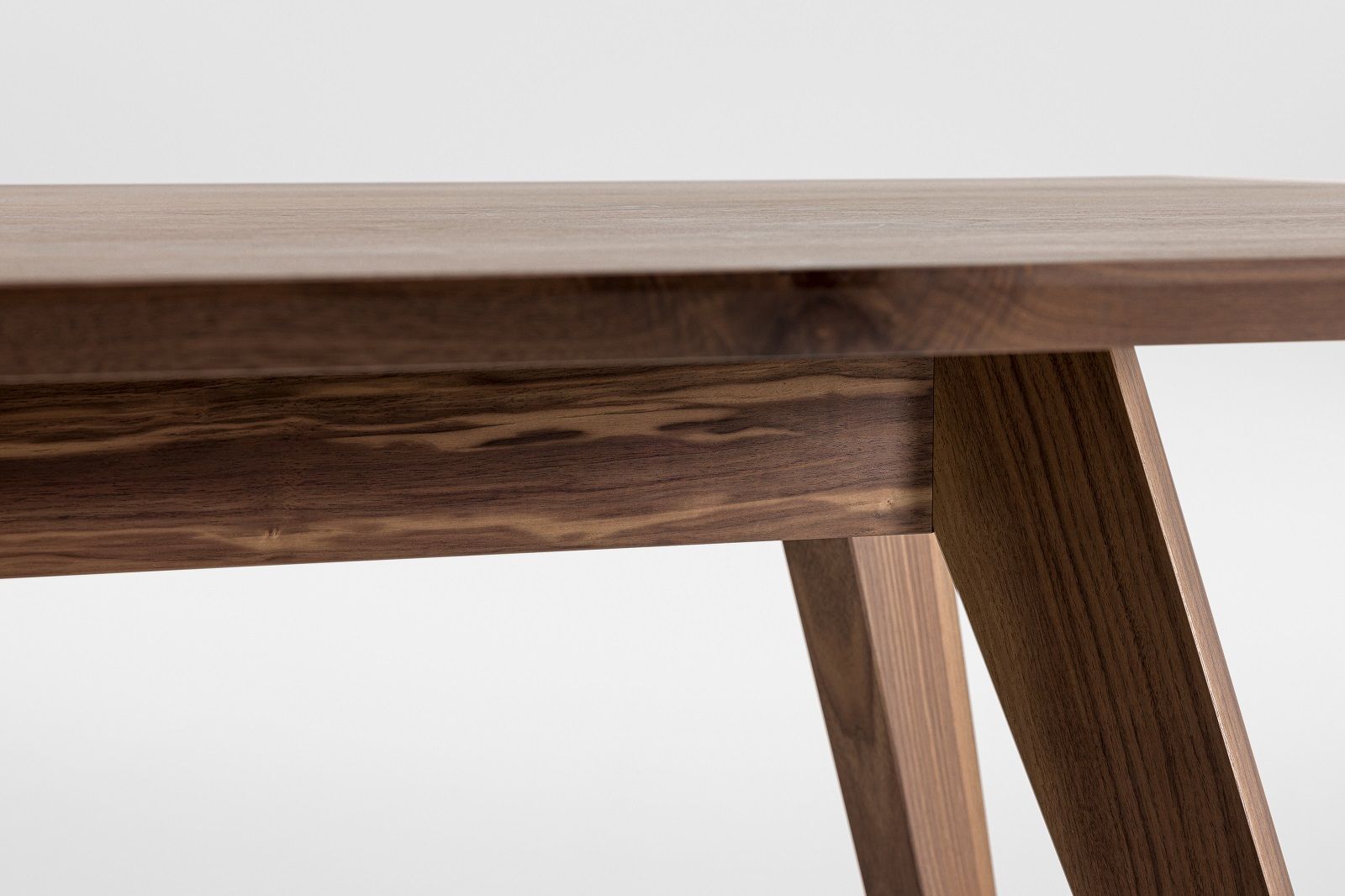 Detailaufnahme des CENA Tisches: Rechteckiger Esstisch aus dunklem Holz mit markanter Maserung.