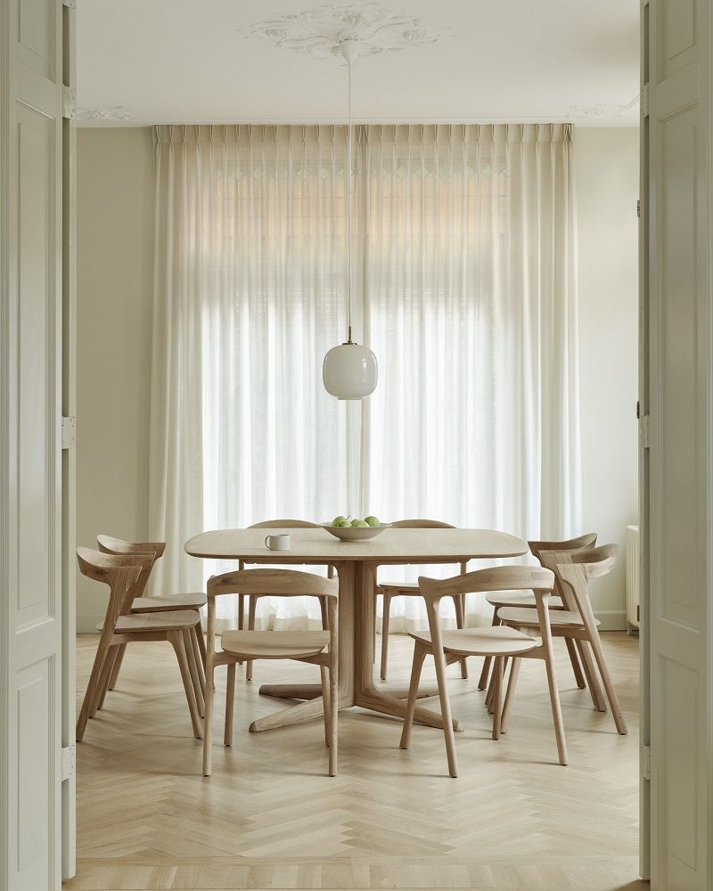 Corto Esstisch von Ethnicraft, quadratisch, aus hellem Holz mit sechs Stühlen in einem hellen Raum.