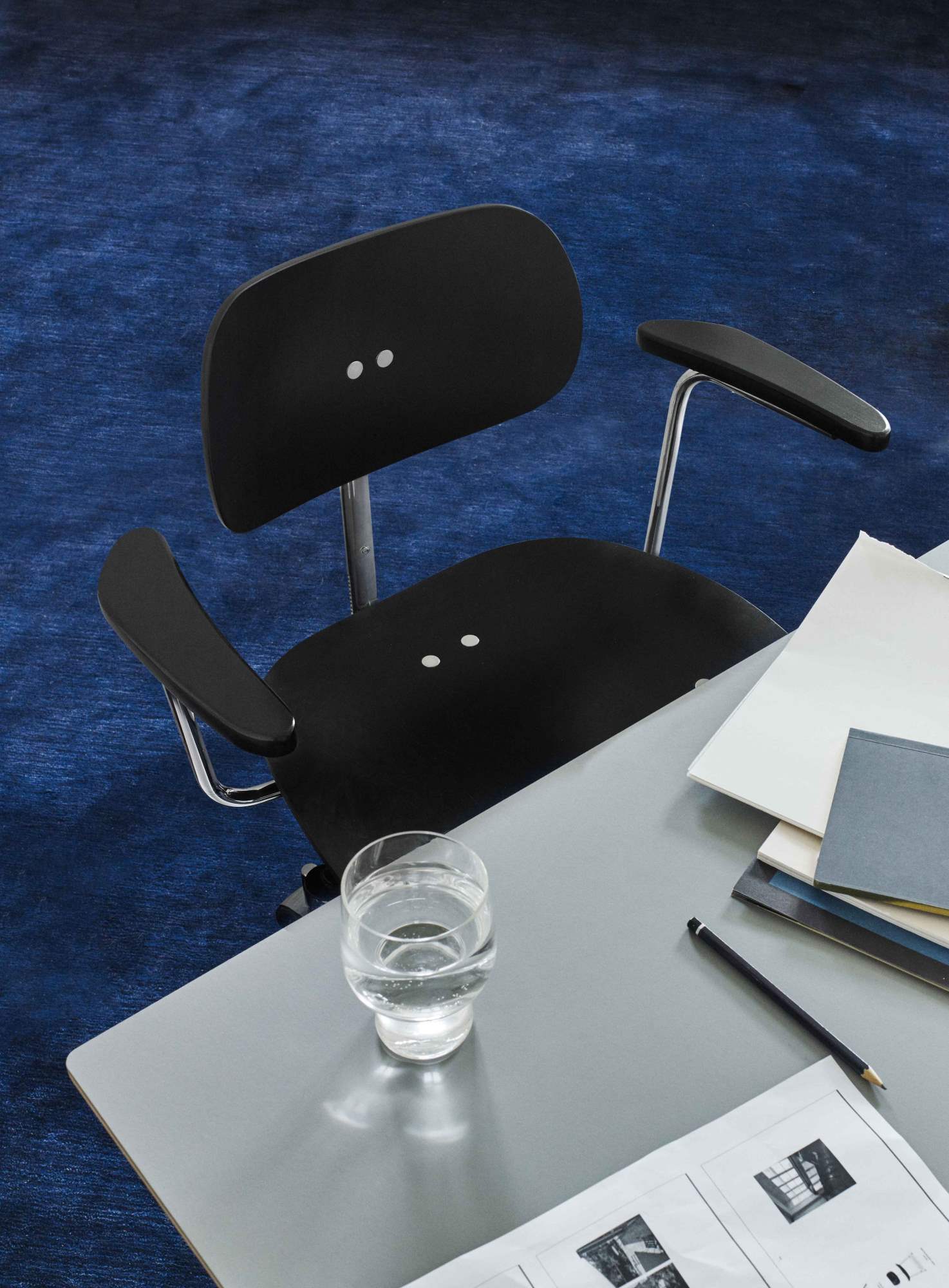 Schwarzer SBG 197 R Drehstuhl von Wilde+Spieth am Schreibtisch mit Glas Wasser.