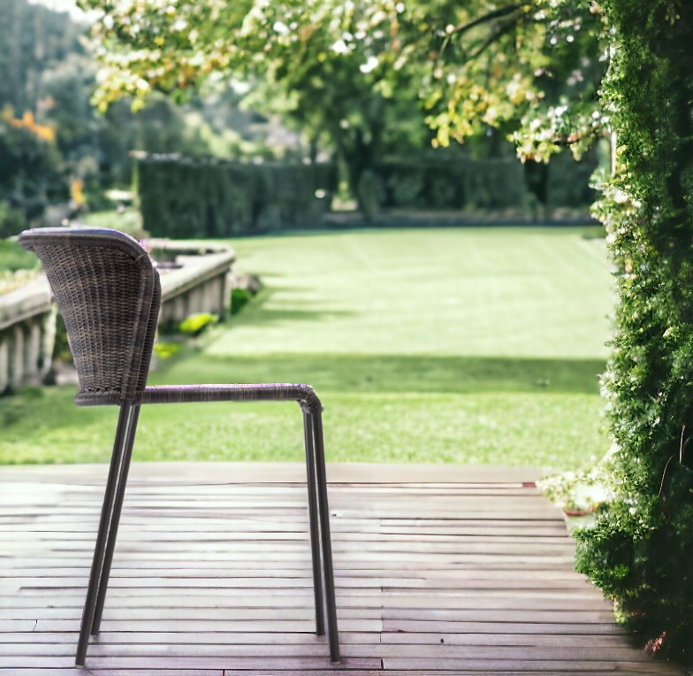 Santa Lucia Outdoor Stuhl von Richard Lampert, brauner Rattanstuhl auf Holzterrasse mit Gartenblick.