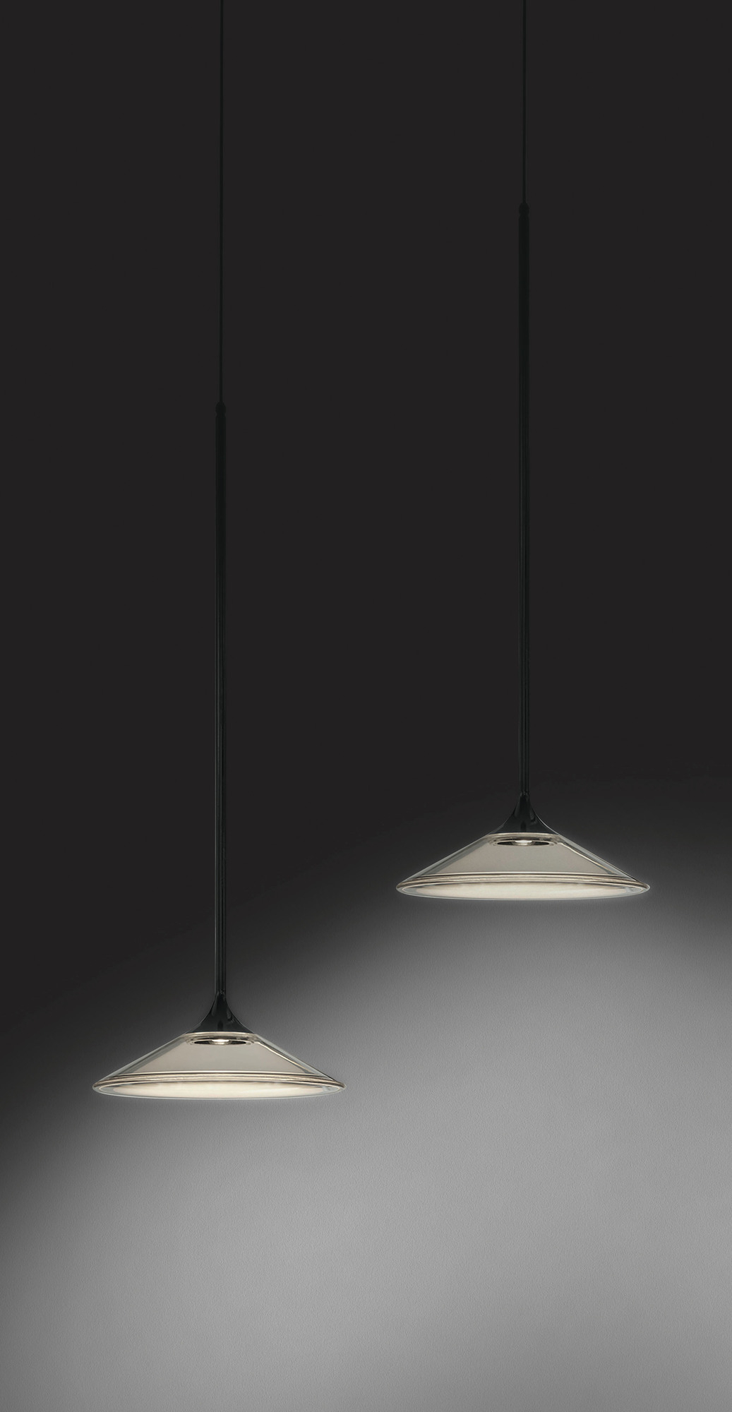 Zwei moderne Orsa Pendelleuchten in Schwarz von Artemide, minimalistisches Design, indirekte Beleuchtung.