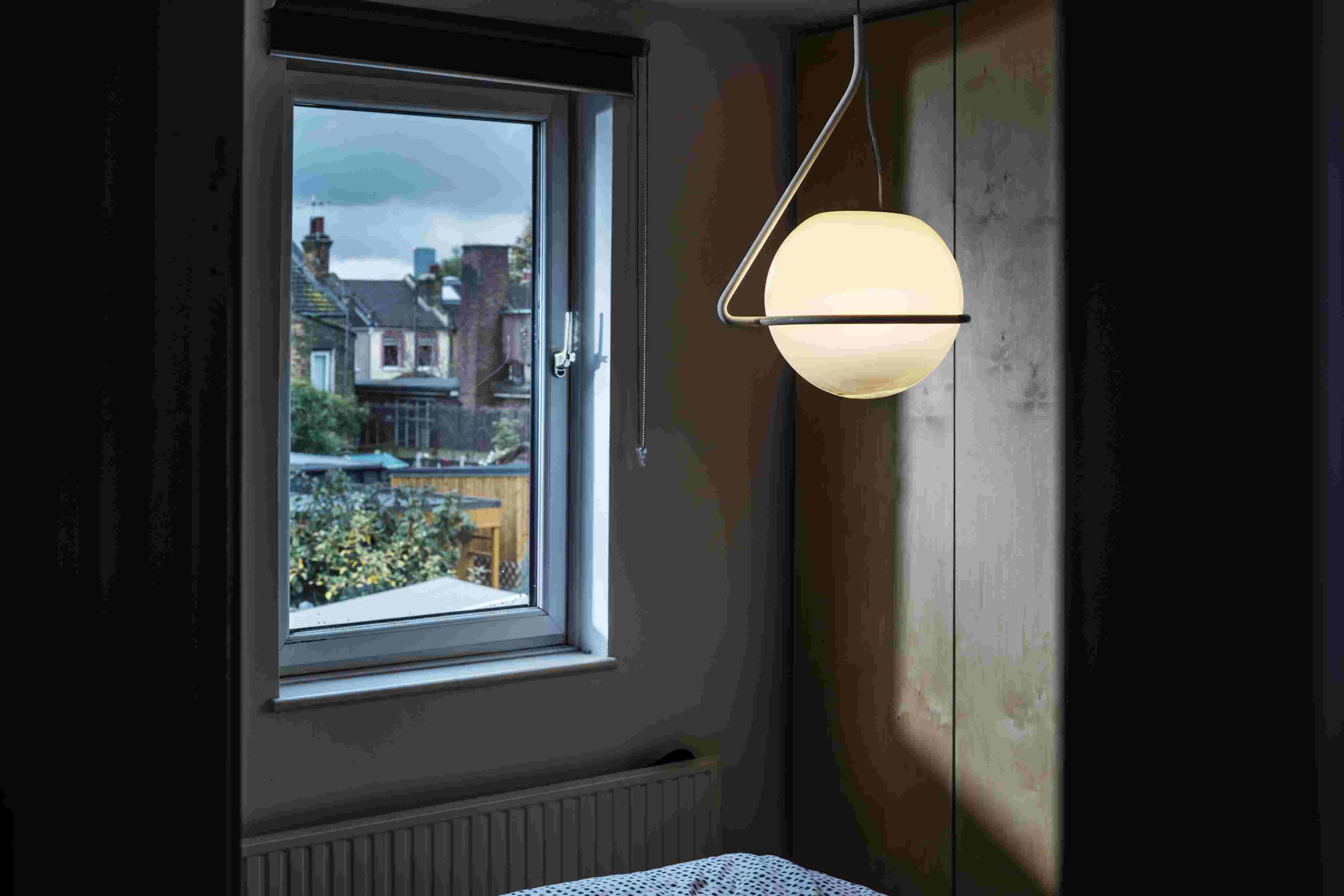 Nahaufnahme der modernen Foscarini Tonda Pendelleuchte mit Kugelform und indirektem Licht im Schlafzimmer.