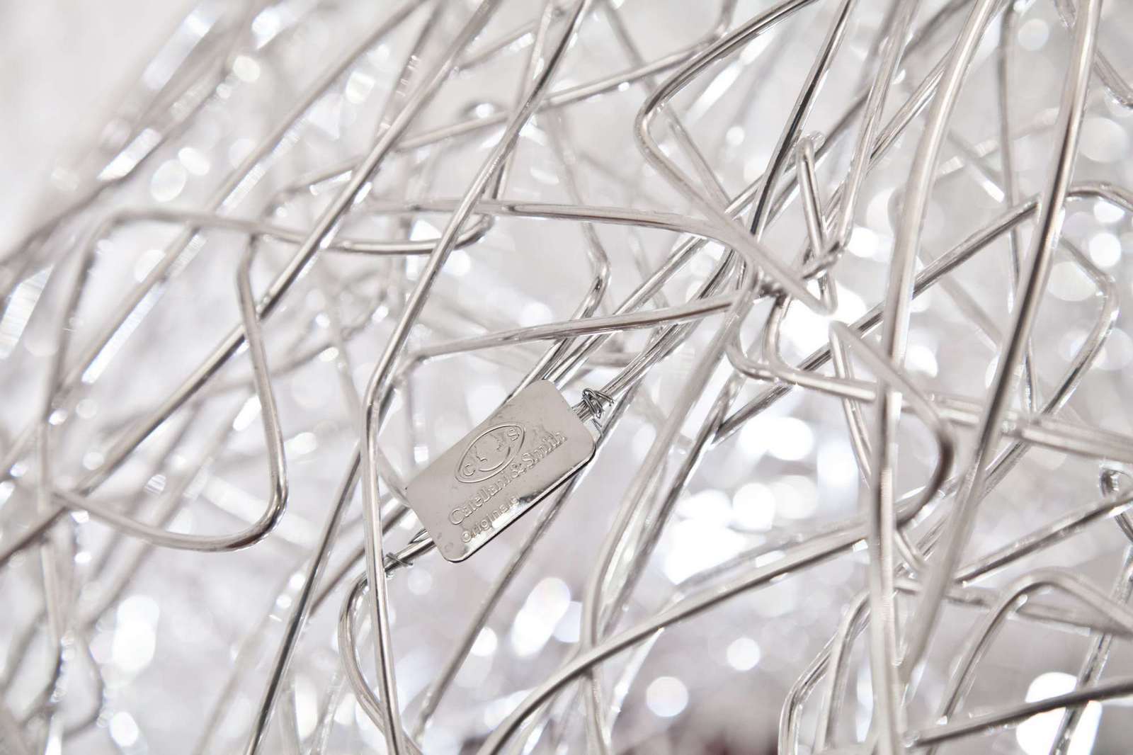 Detailaufnahme der Catellani & Smith Fil de Fer Bodenleuchte mit silbernen Aluminiumdraht und Hersteller-Logo.