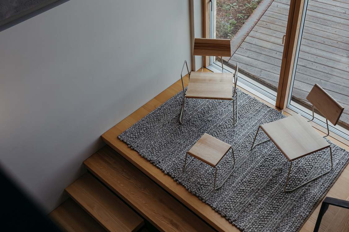 Draufsicht: D:007 Loungechair, Hocker und Tisch von Fuchs & Habicht auf grauem Teppich.