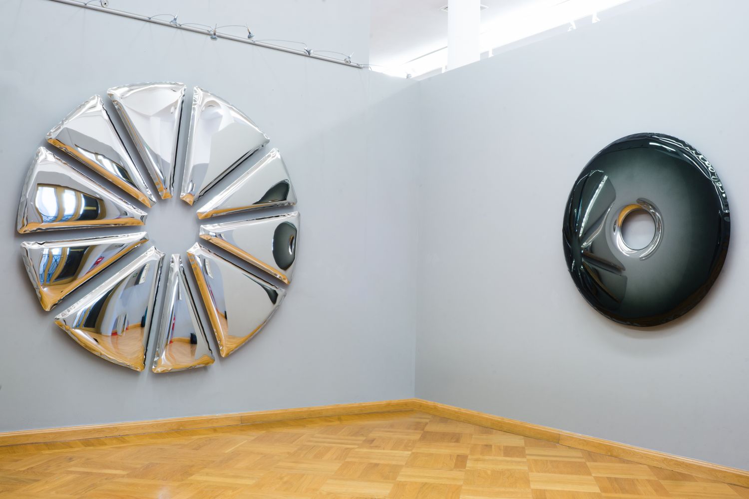 Nucleus Spiegel von Zieta, silberfarben und rund, als Wanddekoration in einem Raum.