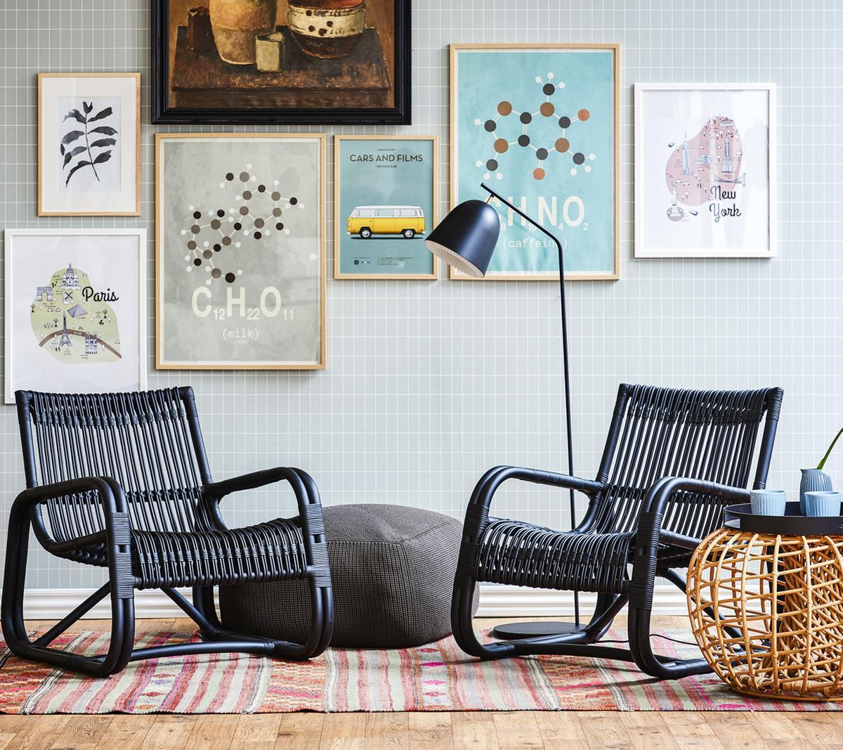 Zwei schwarze Curve Loungesessel von Cane-Line im Innenraum, geflochtenes Design, bequeme Sitzgelegenheit, modernes Möbeldesign.