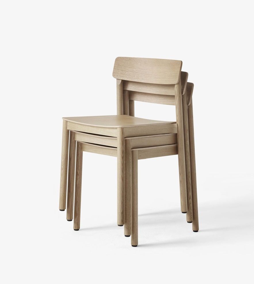 Drei gestapelte, helle Holzstühle, Modell Betty TK2 Chair von AndTradition, auf weißem Hintergrund.