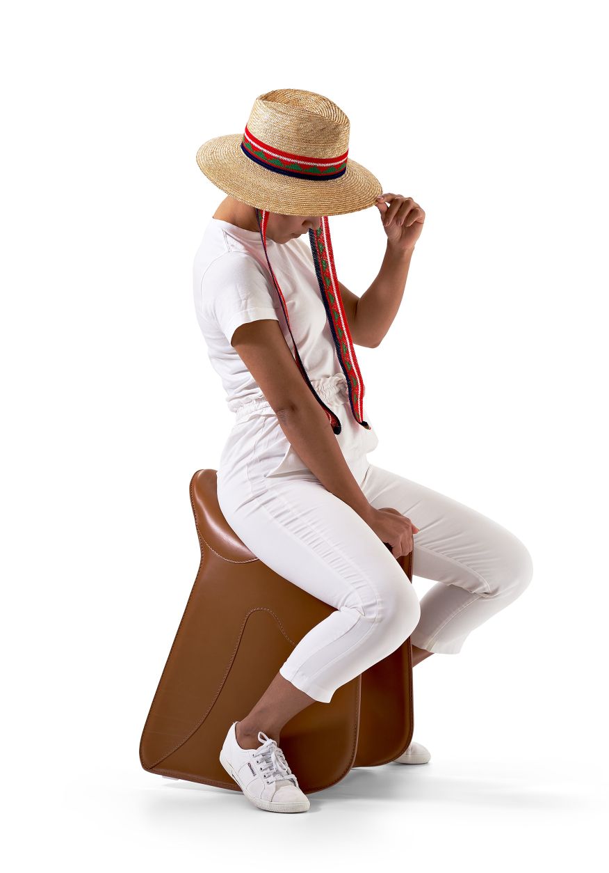 Frau mit Hut sitzt auf braunem Pepe Sitzhocker von Opinion Ciatti.