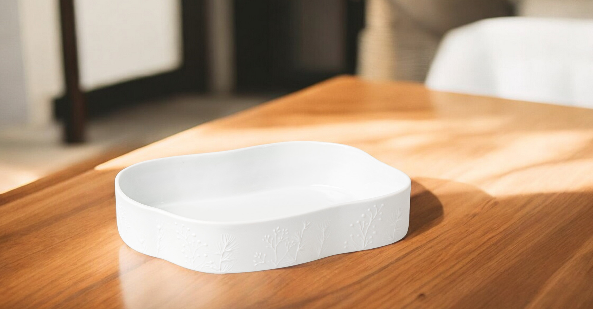 Weiße Räder Schale "Winterzauber" aus Porzellan mit filigranem Pflanzenmuster auf einem Holztisch.