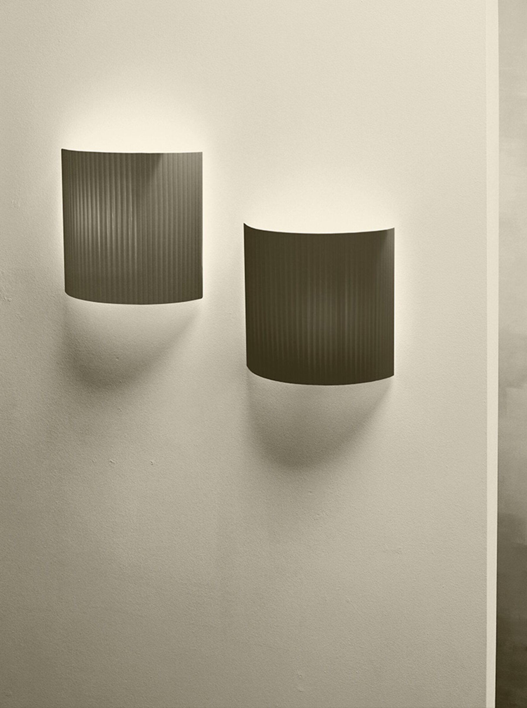 Zwei quadratische Comodín Wandleuchten in Terrakotta-Optik von Santa & Cole an einer Wand.