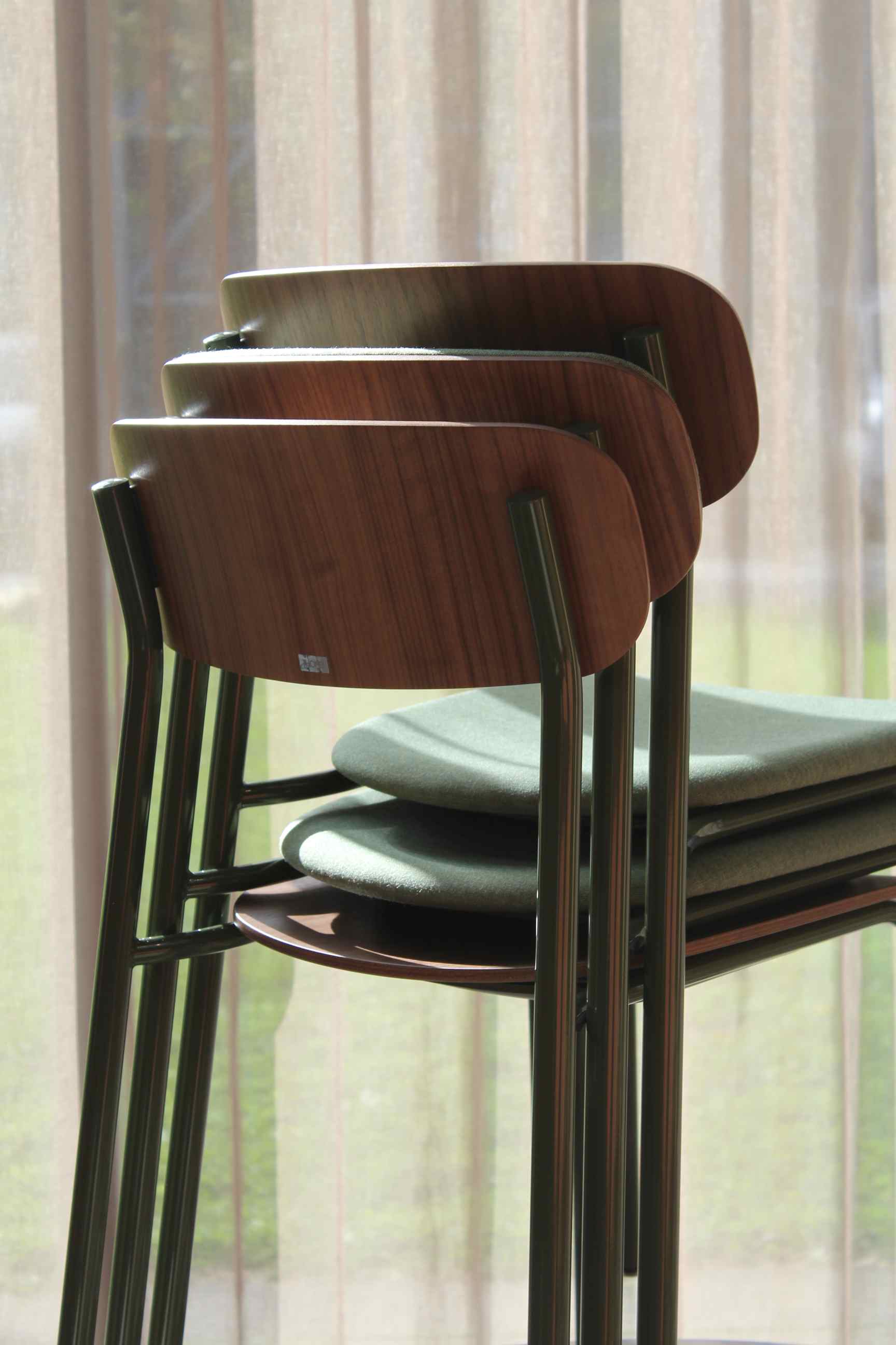 Gestapelte S 243 Stahlrohrstühle von Thonet in Olivgrün mit Holzlehne und Stahlrohrgestell.