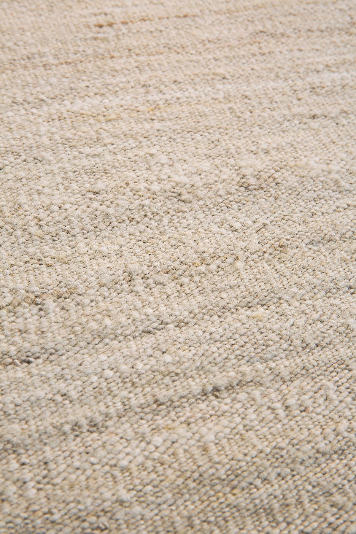Detailaufnahme des beigen Sand Nomad Kilim Teppichs von Ethnicraft (B 250) mit ethnischer Textur.