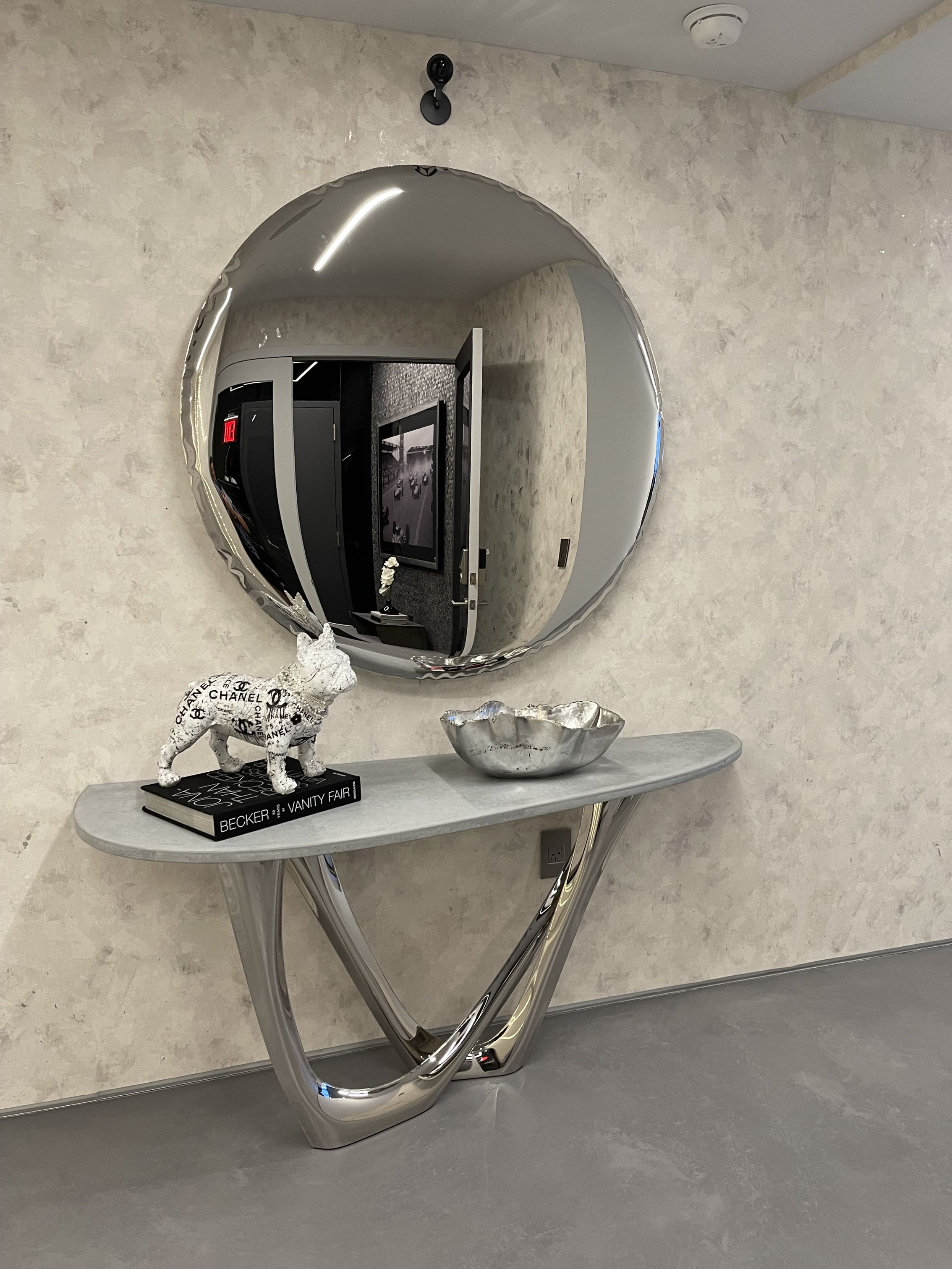 Oko inox Spiegel von Zieta, runder Design-Spiegel aus Edelstahl, reflektiert ein modernes Interieur.