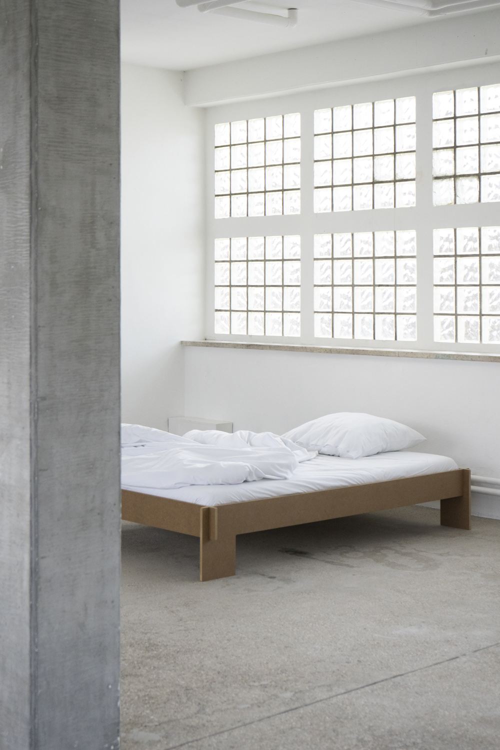 Siebenschläfer Bett von Moormann, B 160 x L 200 cm, mit weißer Bettwäsche in minimalistischem Schlafzimmer.