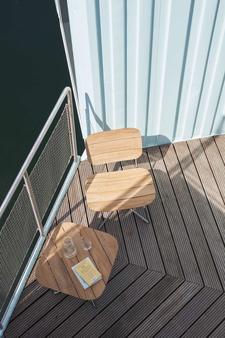 Lilium Lounge Table von Skagerak: Outdoor Tisch aus Teakholz mit Stuhl und Gläsern.