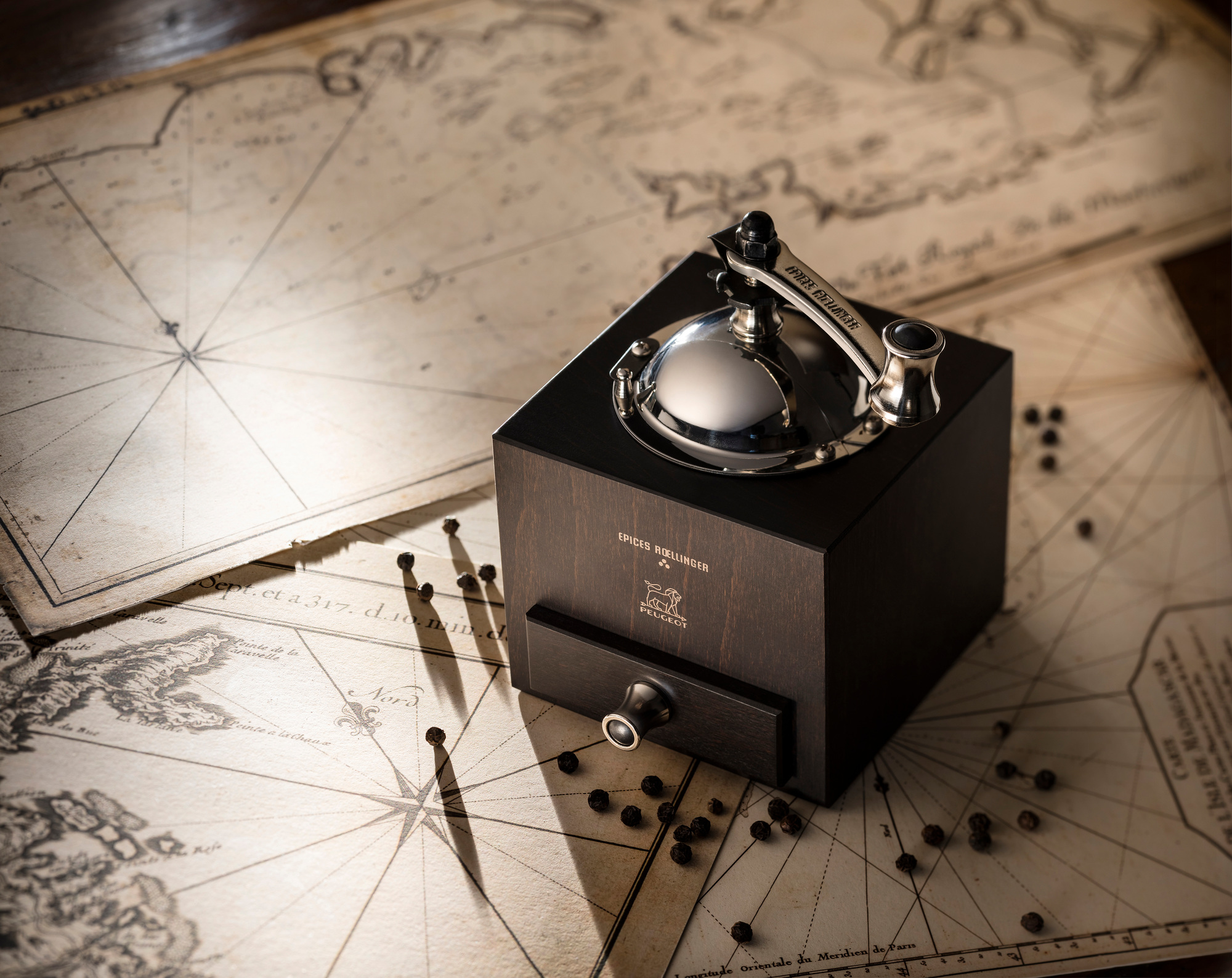 Roellinger Pfeffermühle Peugeot aus Holz mit Schublade und silbernem Mahlwerk auf alter Seekarte.