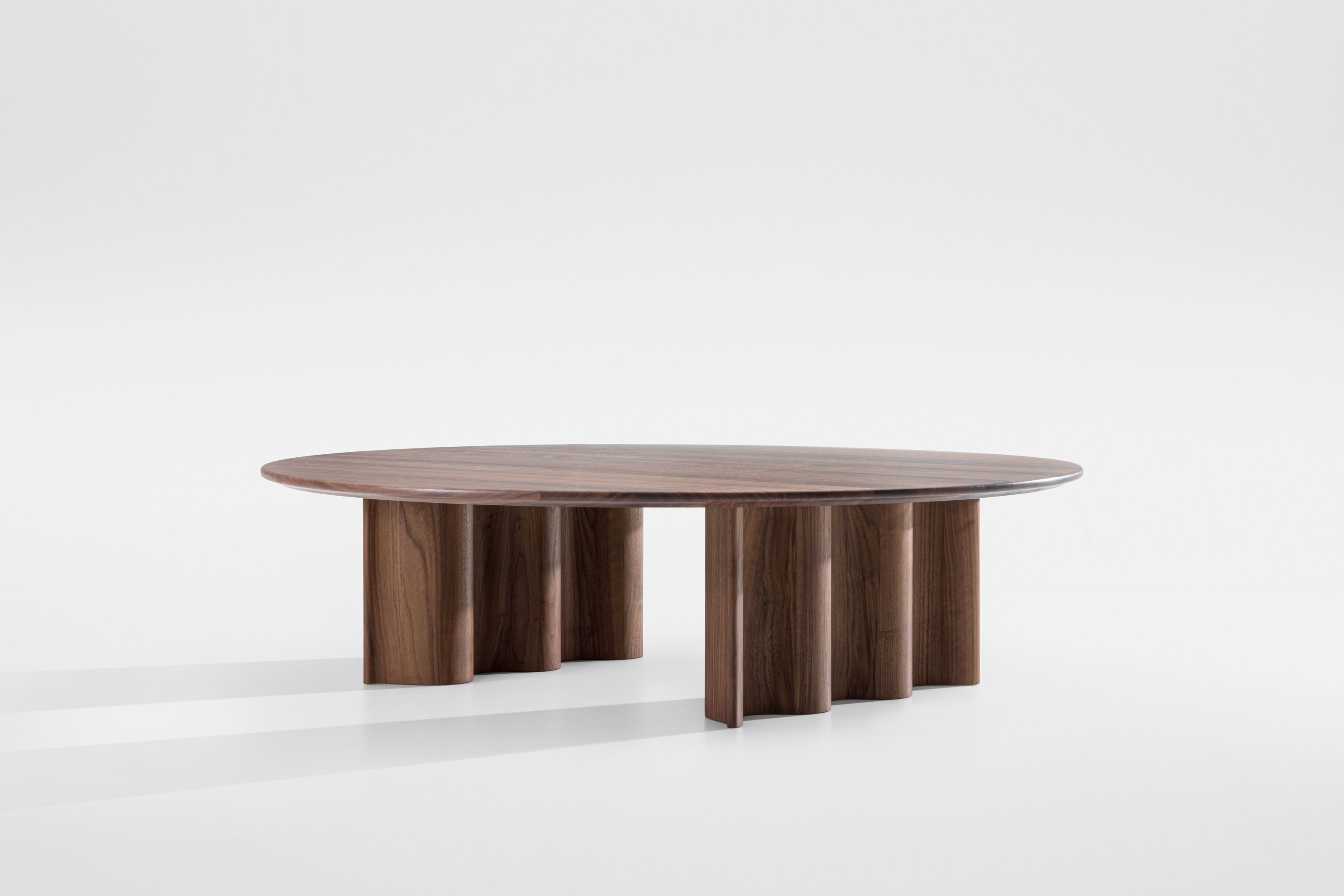 Curtain Couchtisch aus Walnuss: Runder Wohnzimmertisch mit besonderem Design und Holzfüßen.