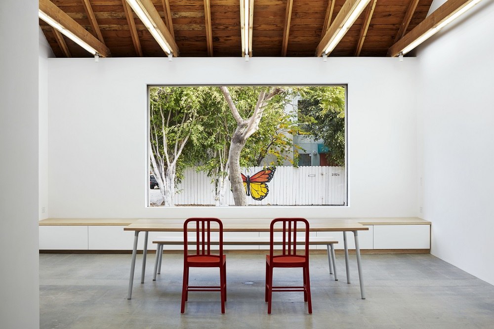 Emeco Run Bench 3-Sitzer Bank Schwarz/Akkoya vor Fenster mit Garten. Design Sitzbank für Esszimmer.