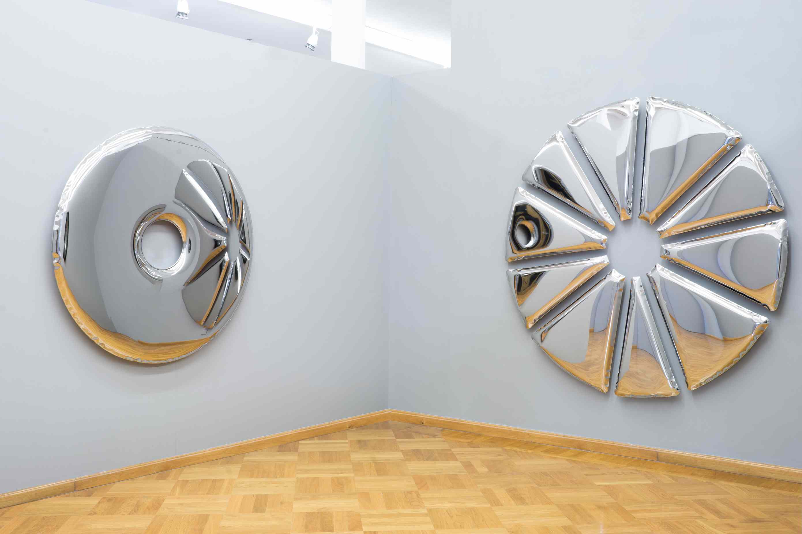 Zwei runde Nucleus Spiegel von Zieta auf einer grauen Wand, modernes Designobjekt.