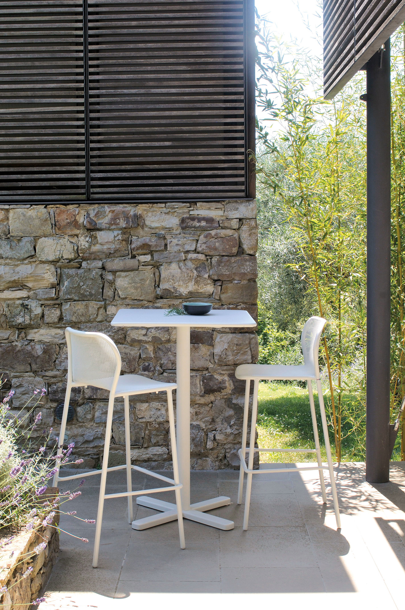 Zwei weiße emu Barhocker der Serie Darwin mit passendem Tisch im Außenbereich.