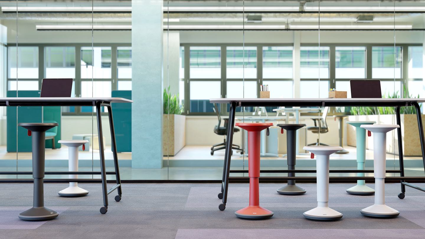 Interstuhl UPis1 Stehhocker in Zitronengelb und weiteren Farben im modernen Büro für ergonomisches, dynamisches Sitzen.