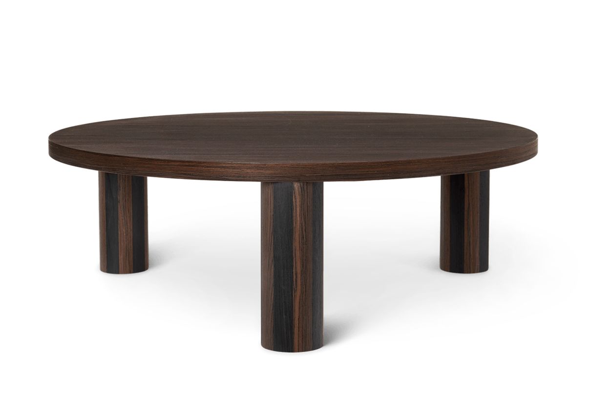 Runder, dunkler Holz-Kaffeetisch "Post" von Ferm Living mit drei zylindrischen Beinen.