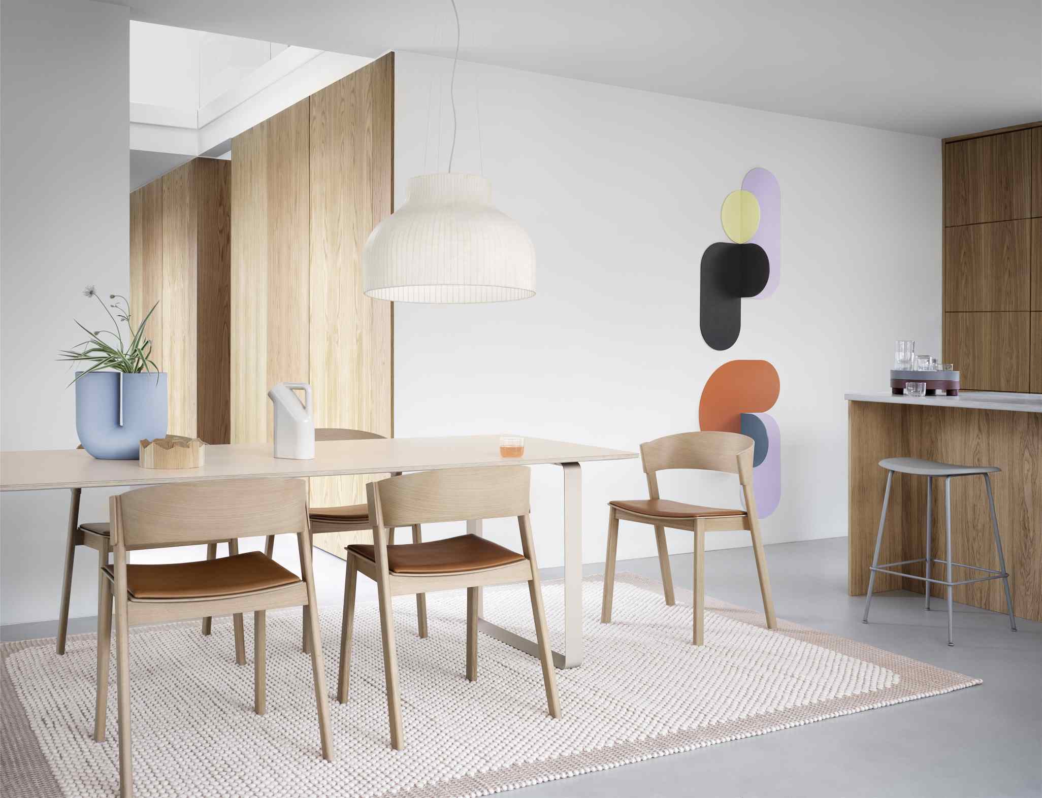 Esszimmer mit Muuto Side Chair Stühlen aus Holz und Leder am Esstisch.