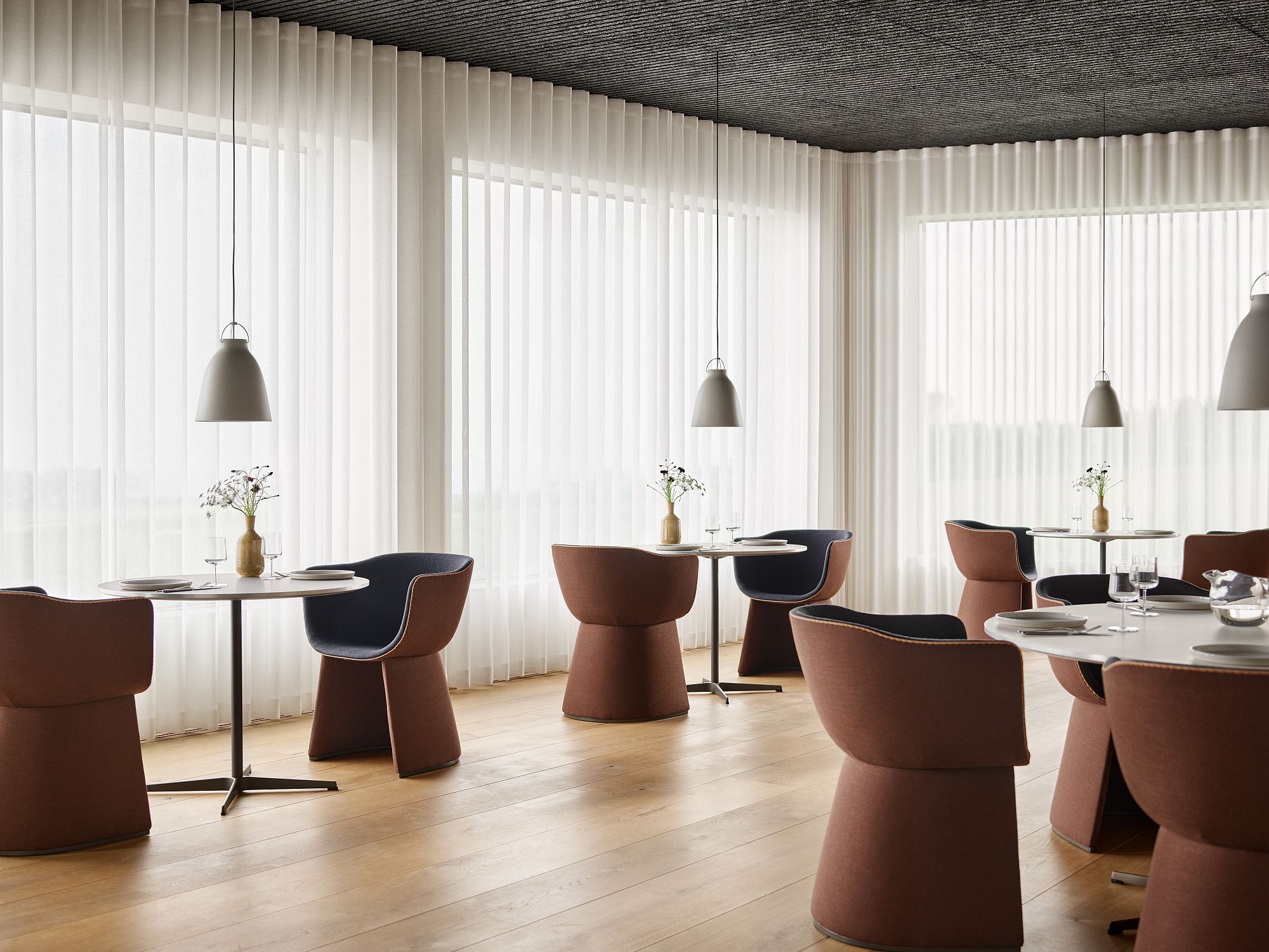 Innenansicht mit Monolit Loungesessel / Esszimmerstuhl von Fritz Hansen an Tischen in einem Restaurant.