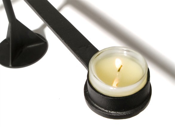 Detailaufnahme des schwarzen Tom Dixon Spin Kerzenständers mit brennender Kerze im Glas.