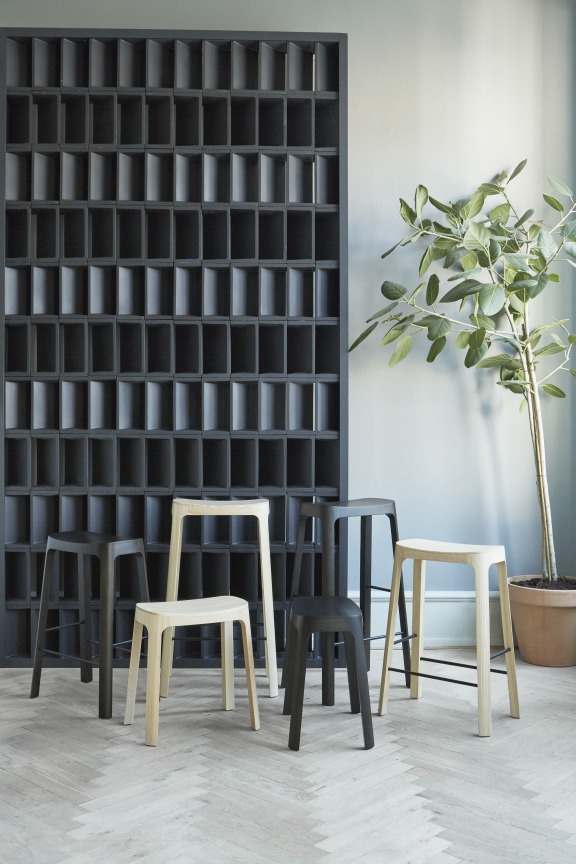 Crofton Barhocker "Please wait to be seated" in verschiedenen Farben vor dekorativer Wand. Design Barstühle.