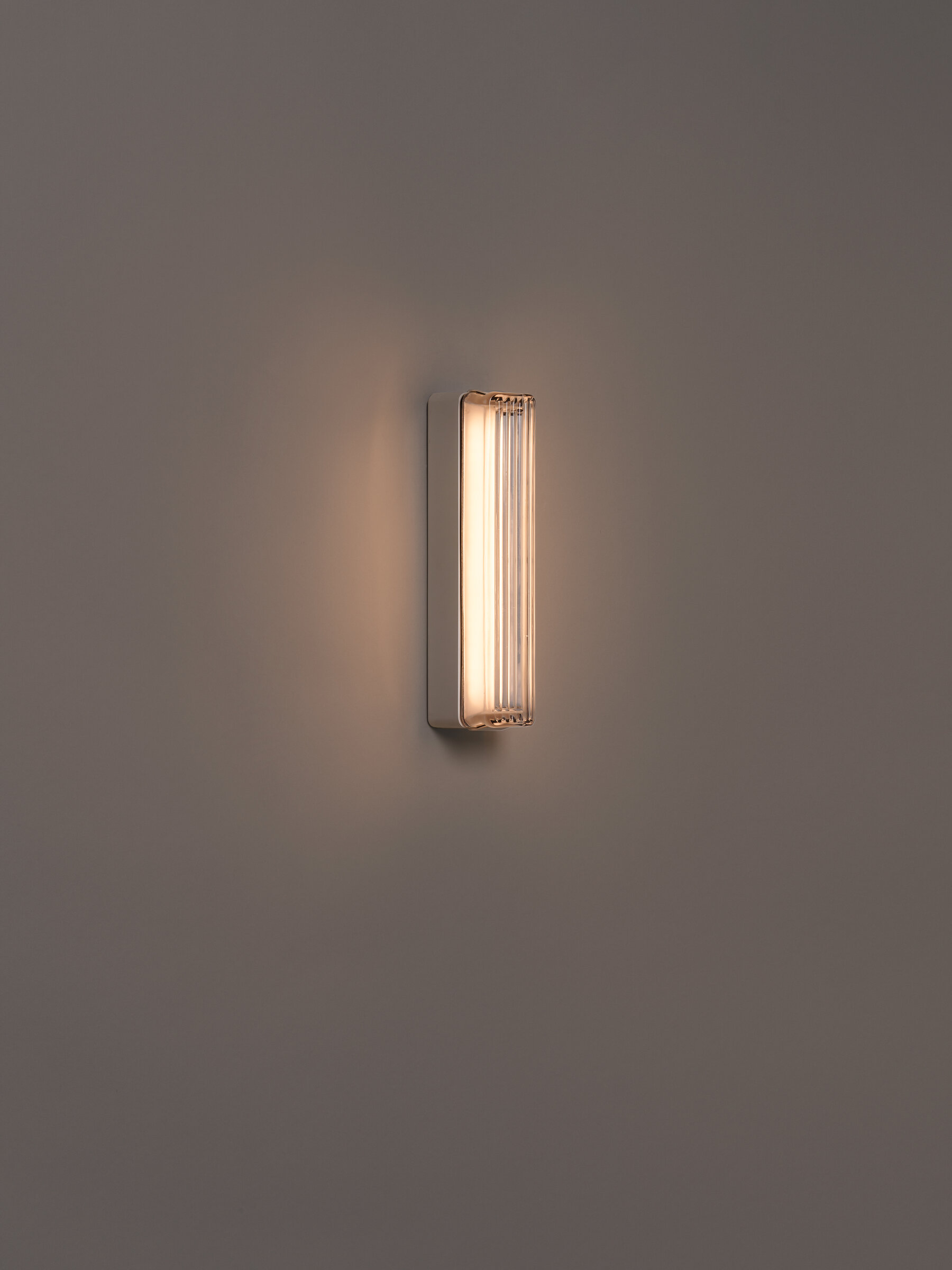 Weiße Estadio Singluar Wandleuchte von Santa & Cole, moderne Innenleuchte mit vertikalen Glasstäben.