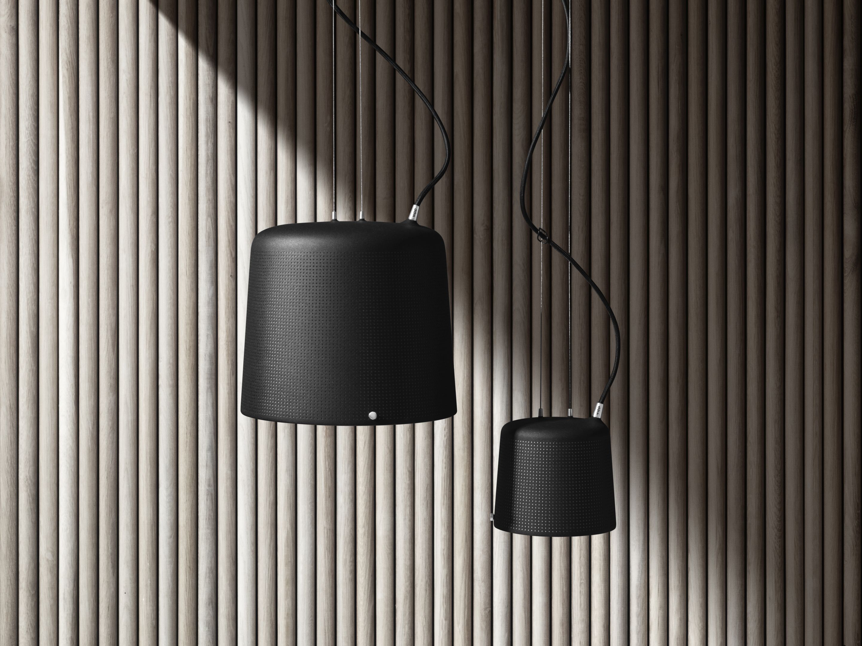 Zwei schwarze Vipp Pendelleuchten, moderne Hängelampen für Wohnzimmer und Esszimmer, vor einer Holzpaneelwand.