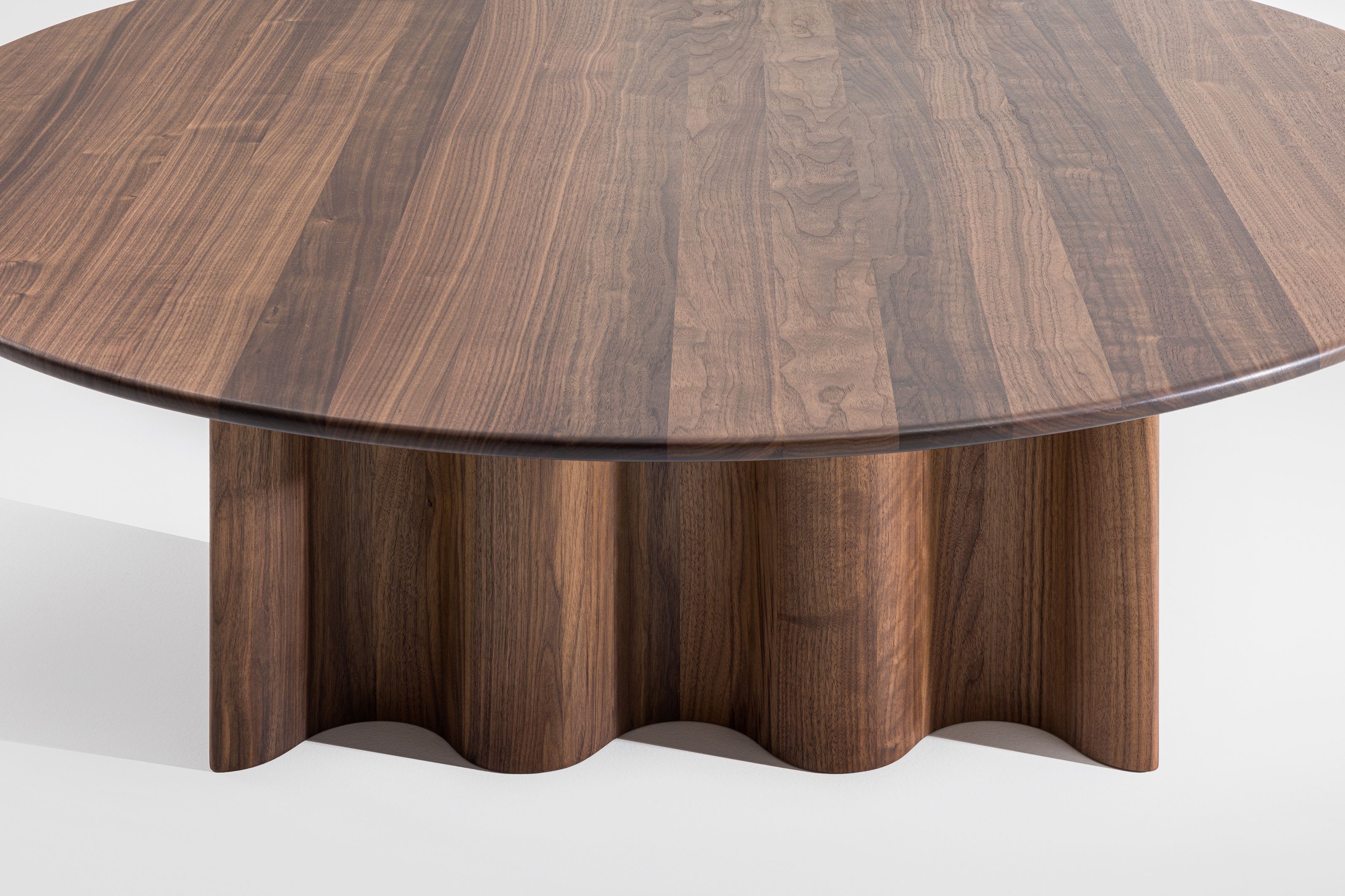 Runder Couchtisch aus Walnussholz mit geriffelter Basis. Modernes Design für Wohnzimmer und Wartebereiche.