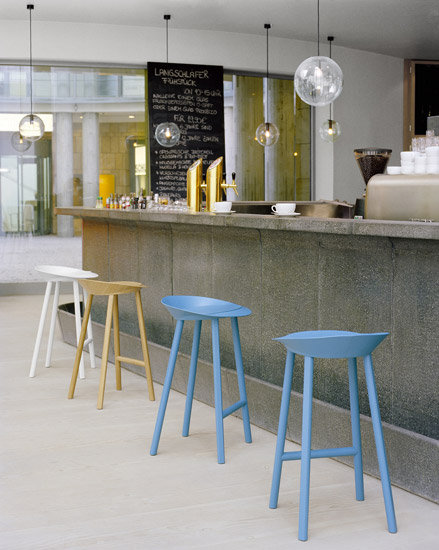 Reihe von ST10 Jean Hockern e15 in verschiedenen Farben an einer Bar.