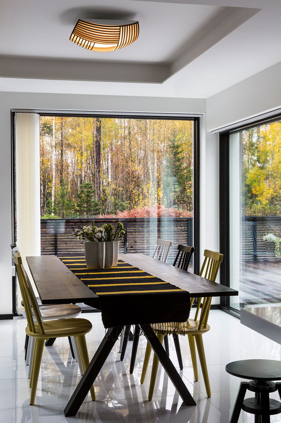 Kuulto 9100 Deckenleuchte von Secto Design aus Birke über Esstisch mit Stühlen und Fenster.