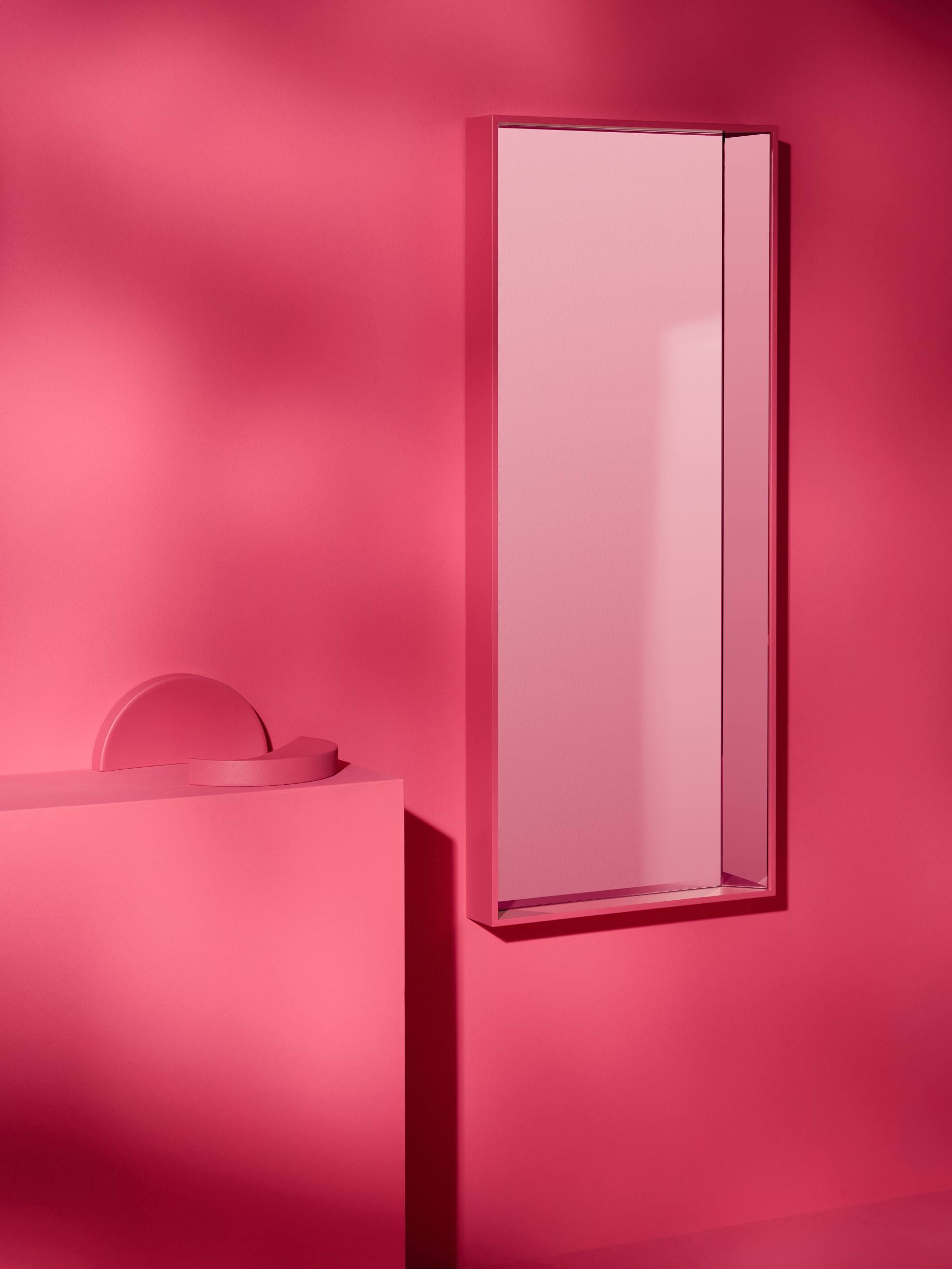 Kon Spiegel von Schönbuch, rechteckig, pink, an pinker Wand mit geometrischen Dekoelementen.